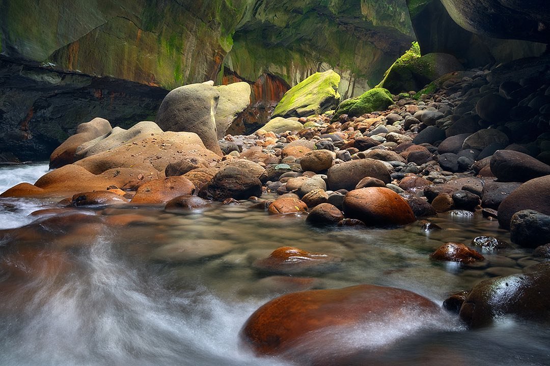 Un río con muchas piedras de todos los tamaños aparentemente en un cañon