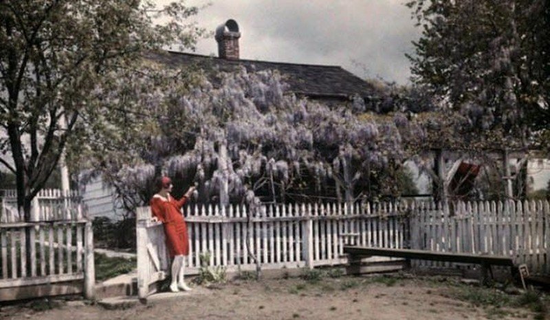 Una mujer con vestido rojo en el patio de una casas. De las Modas raras de la fotografía